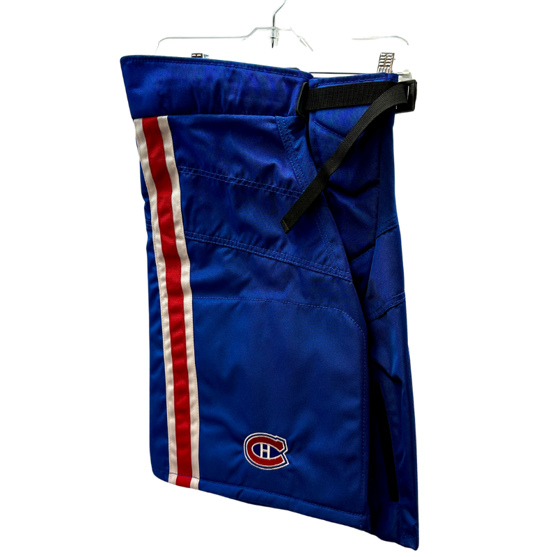 Warrior NHL Pro Return Montreal Canadiens Pant Shells folded in half showing Montreal Canadiens logo, hanging from clothes hanger