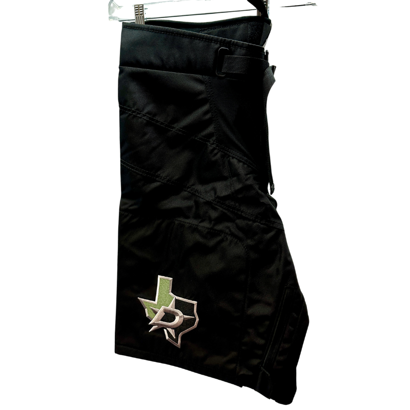 Warrior NHL Pro Return Dallas Stars Pant Shells folded in half showing Dallas Stars logo, hanging from clothes  hanger